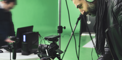 Camera, computer, green screen and two men.