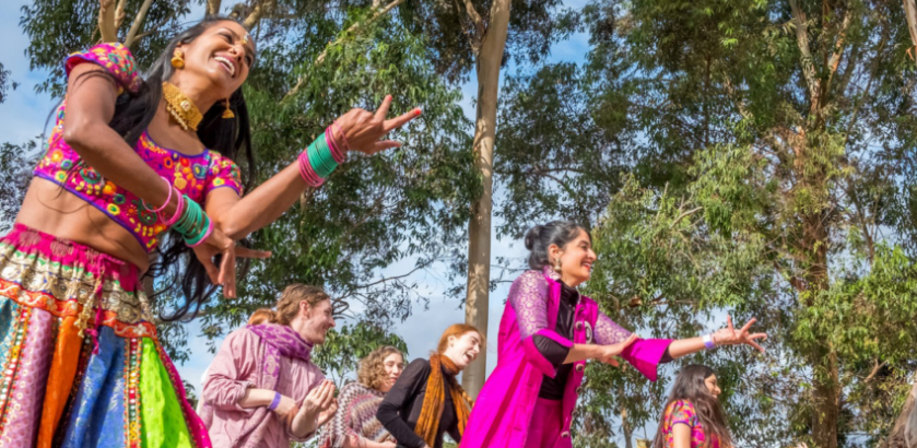 This image shows a group of women dancing in Bollywood style at an outdoor festival.