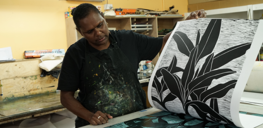 First Nations artist at the printing press in an art centre.