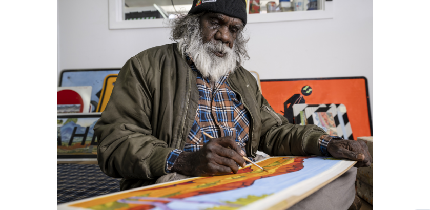 Mervyn Rubuntja 2021, painting in the Iltja Ntjarra Studio. Image courtesy: Shaana McNaught, Tourism NT.