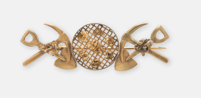 An intricate colonial-era gold brooch with goldfield motifs.