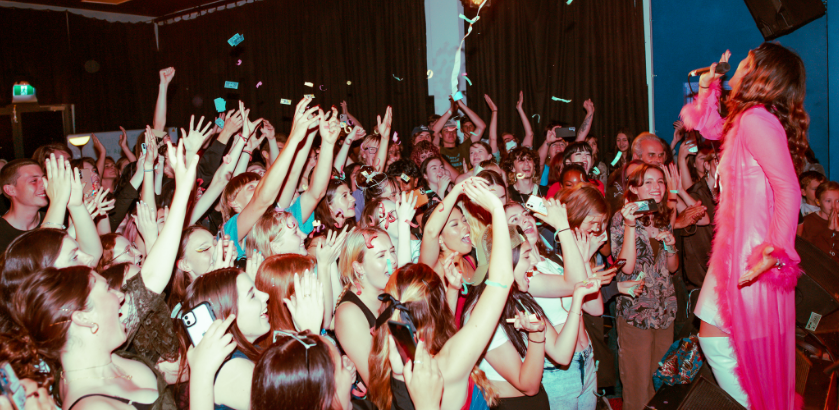  Photo of the singer Siena Rebelo performing on stage in front of a live audience.