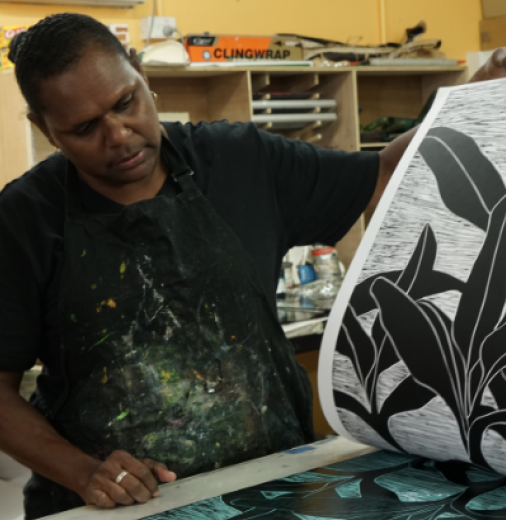 First Nations artist at the printing press in an art centre.