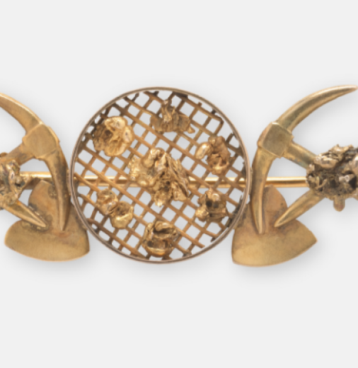 An intricate colonial-era gold brooch with goldfield motifs.